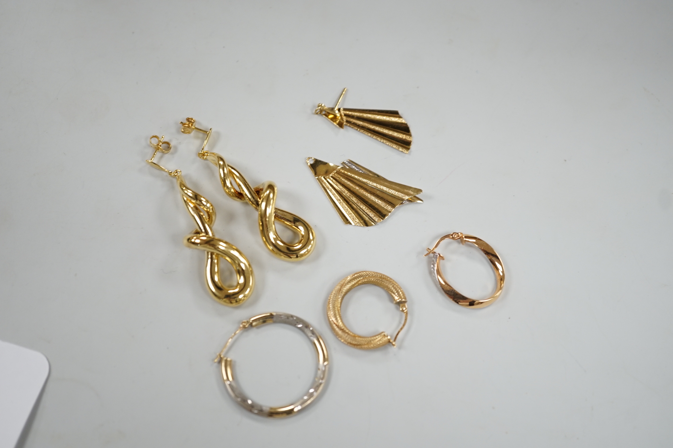 A modern pair of 9ct gold scrolling drop earrings, 47mm, three odd 9ct gold earrings and three 9ct earring fragments, 13.4 grams.